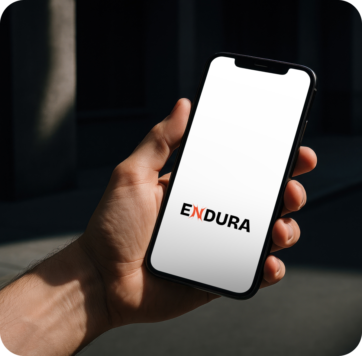 Hand holding phone showing Endura logo